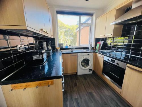 a kitchen with a washer and a washing machine at Family Marine Apartment with Sea View in Dawlish