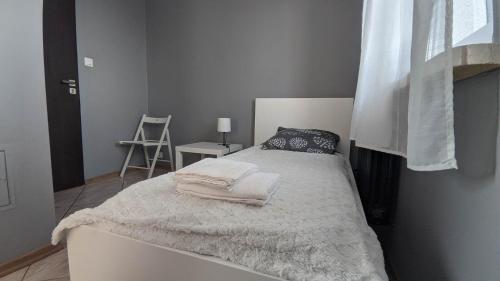Una cama blanca con toallas en un dormitorio en Seaside Apartment, en Gdansk