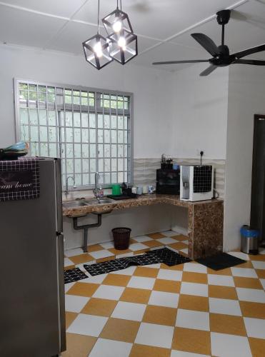 a kitchen with a table and a ceiling fan at ARYAN HOMESTAY Temerloh in Temerloh