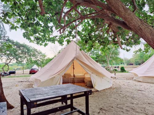 a tent with a picnic table in front of it at Rustika Glamping in Kampong Tanjong Che Lahom