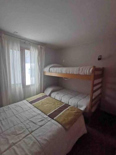 a bedroom with two bunk beds and a window at Departamento Termas de Chillán in Pinto
