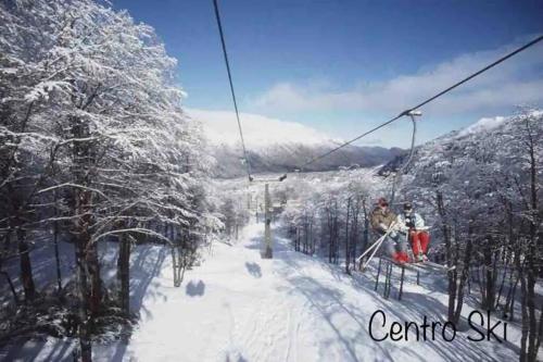 two people on a ski lift in the snow at Departamento Termas de Chillán in Pinto