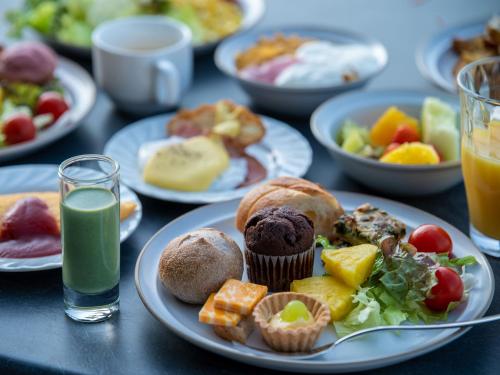 a table with plates of breakfast foods and drinks at Hitoyoshi Onsen Nabeya in Hitoyoshi