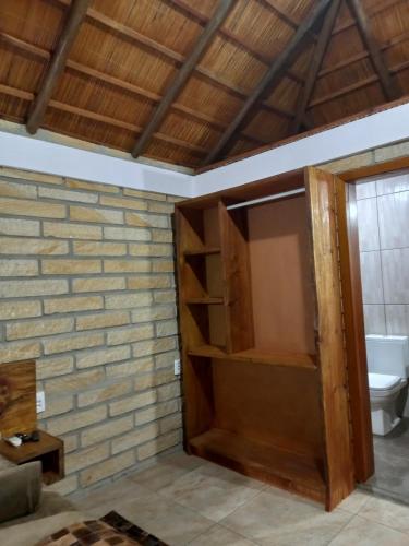 baño con puerta de madera y aseo en KARAPOTÓ parador rural, en Cambará