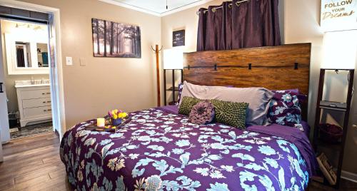 a bedroom with a bed with a purple comforter at 1 Sweet Retreat in Nashville