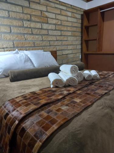 Una cama con toallas encima. en KARAPOTÓ parador rural, en Cambará