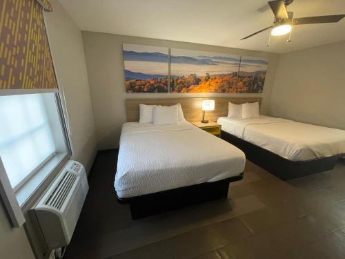 a hotel room with two beds and a window at Days Inn by Wyndham Holladay in Holladay