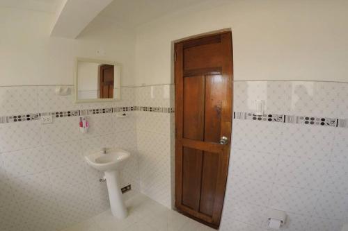 La salle de bains est pourvue d'un lavabo et d'une porte en bois. dans l'établissement Centric & cozy apartment with Garage, à Cusco