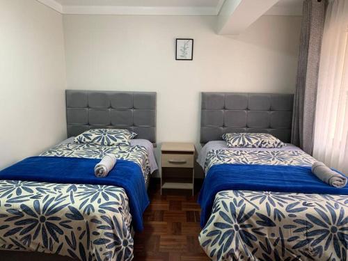 une chambre avec deux lits avec des draps bleus et blancs dans l'établissement Centric & cozy apartment with Garage, à Cusco