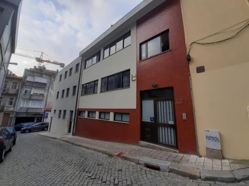 un edificio rojo y blanco al lado de una calle en Spacious economic Center Porto Flat, en Oporto