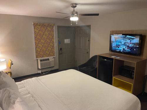 a hotel room with a bed and a flat screen tv at Days Inn by Wyndham Holladay in Holladay