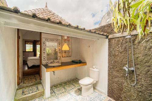 a bathroom with a toilet and a shower in it at Four Monkeys House in Bedugul