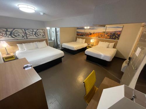 a hotel room with two beds and a desk at Days Inn by Wyndham Holladay in Holladay