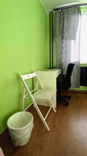 a green room with a desk and a chair at Seaside Apartment in Gdańsk