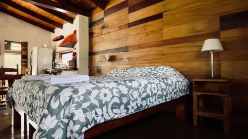 a bedroom with a bed with a wooden wall at Finca Villa Maria in Yala