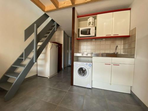une cuisine avec un lave-linge et un escalier dans l'établissement Appt cosy 4 pers avec piscine et parking, proche plage à Gruissan - FR-1-229-863, à Gruissan