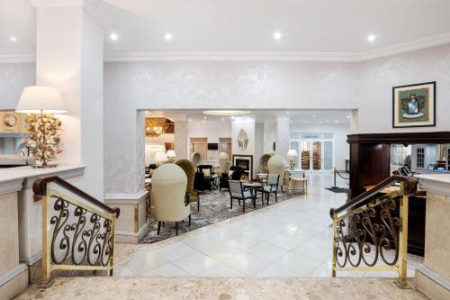 a living room with chairs and a dining room at Protea Hotel by Marriott Johannesburg Balalaika Sandton in Johannesburg