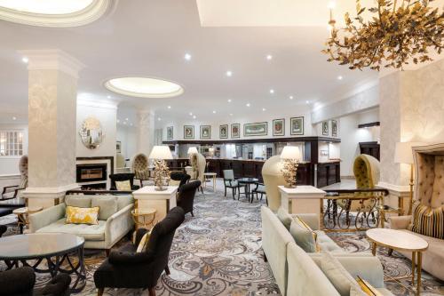 a lobby with couches and tables and a fireplace at Protea Hotel by Marriott Johannesburg Balalaika Sandton in Johannesburg