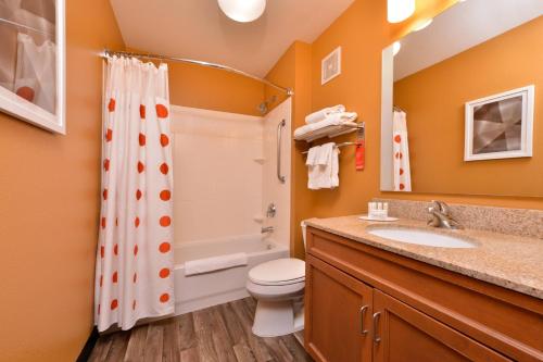 a bathroom with a toilet and a shower and a sink at TownePlace Suites by Marriott Ontario Airport in Rancho Cucamonga