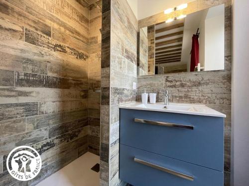 uma casa de banho com um armário azul e um lavatório em Gîte Challans, 4 pièces, 8 personnes - FR-1-426-531 em Challans