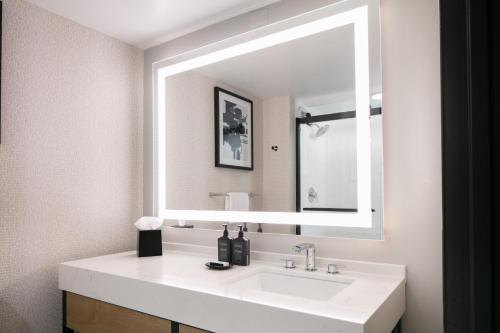 y baño con lavabo blanco y espejo. en Sheraton Overland Park Hotel at the Convention Center en Overland Park