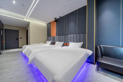 eine Reihe weißer Betten in einem Zimmer mit Stuhl in der Unterkunft Fd Club Hotel - Qian Tan in Shanghai