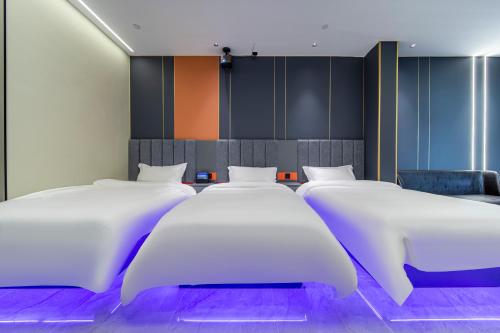 a row of white beds in a room at Fd Club Hotel - Qian Tan in Shanghai