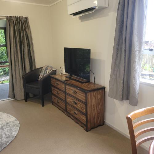 a living room with a television on a dresser at Couples Retreat in Reefton