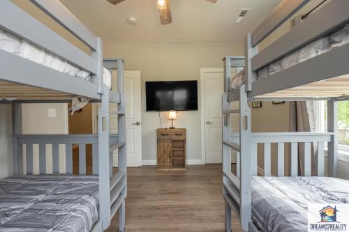 a bedroom with two bunk beds and a flat screen tv at Luxury 3BR Condo - Stairs Required - Resort Amenities - FREE TICKETS INCLUDED - FHG-308 in Branson