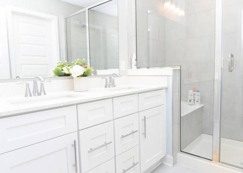 a white bathroom with two sinks and a shower at 3bed 2.5 bath town house in Carmel in Carmel