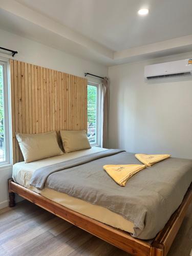 a bedroom with a large bed with a wooden headboard at Kala Krang Nueng in Ko Samed