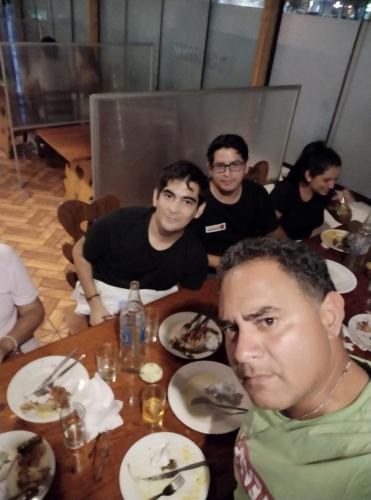 a group of men sitting at a table with food at Ambigua Hospedaje in Trujillo