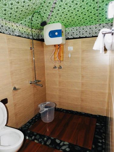 a bathroom with a toilet and a trash can at Camp Dharamshala in Dharamshala