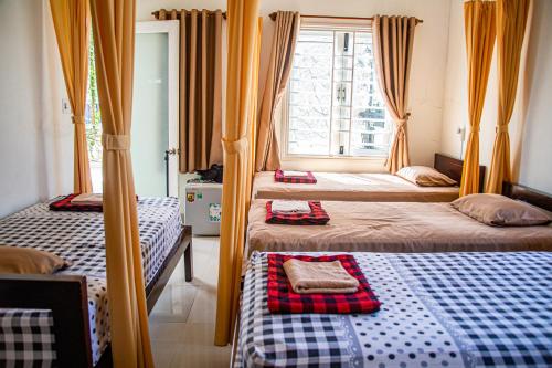 1 dormitorio con 2 camas y ventana en Skybird Homestay en Hoi An