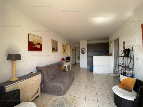un salon avec un canapé et une cuisine dans l'établissement Appartement avec balcon, proche commerces et plages - FR-1-100-309, à Cavalaire-sur-Mer