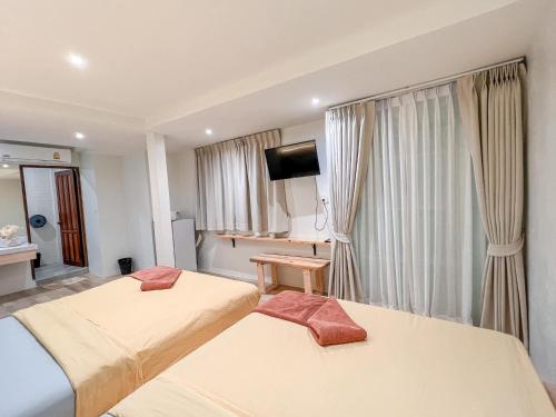 a hotel room with two beds and a flat screen tv at Kala Krang Nueng in Ko Samed