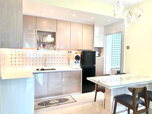 a kitchen with a black refrigerator and a table at Renai Homestay Ladang Tanjung Kuala Terengganu with POOL in Kuala Terengganu