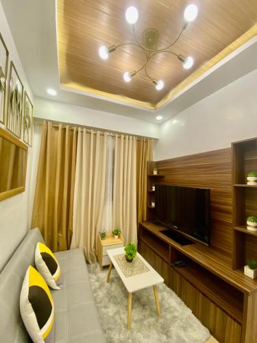 ein Wohnzimmer mit einem Sofa und einem TV in der Unterkunft Apple One in Cebu City