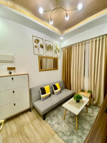 ein Wohnzimmer mit einem Sofa und einem Tisch in der Unterkunft Apple One in Cebu City