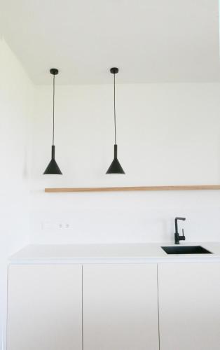 three lights hanging over a white kitchen counter at Haus Münsterblick in Reichenau