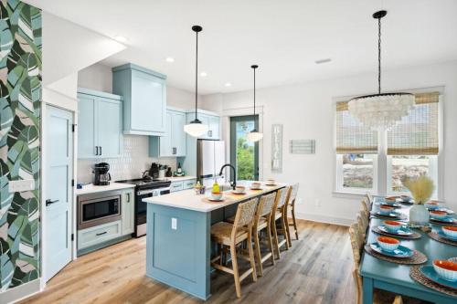 a kitchen with blue cabinets and a table with chairs at Tortuga Tillys in Cape San Blas