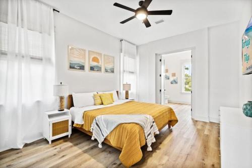 a white bedroom with a bed and a ceiling fan at Tortuga Tillys in Cape San Blas