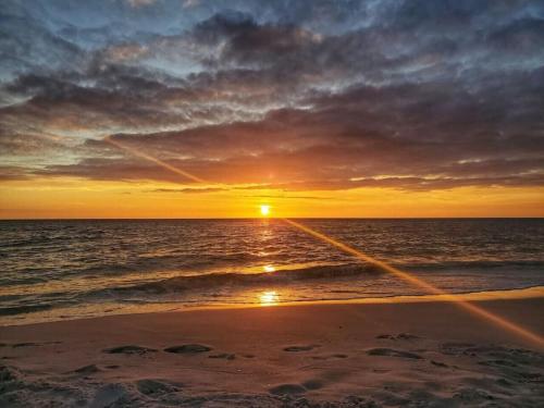 a sunset on the beach with the ocean at Tortuga Tillys in Cape San Blas