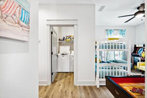 a white room with a crib and a kitchen at Tortuga Tillys in Cape San Blas