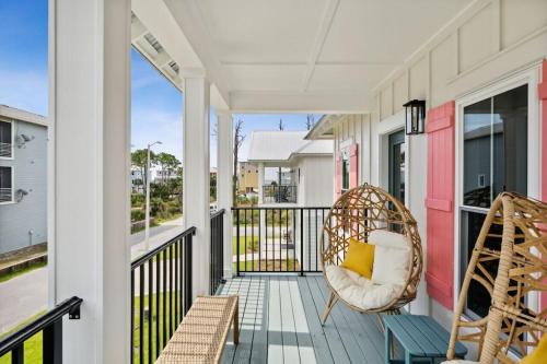 a porch with two chairs and a swing at Tortuga Tillys in Cape San Blas
