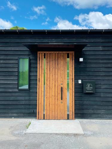 a wooden door on a black building with a window at and RIVER KATSUURA in Katsuura