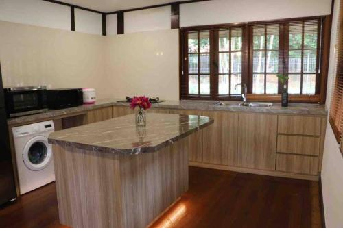 a kitchen with a counter with a vase of flowers on it at Private Tropical 3 Bedroom Villa - Nongsa Village Batam in Telukmataikan