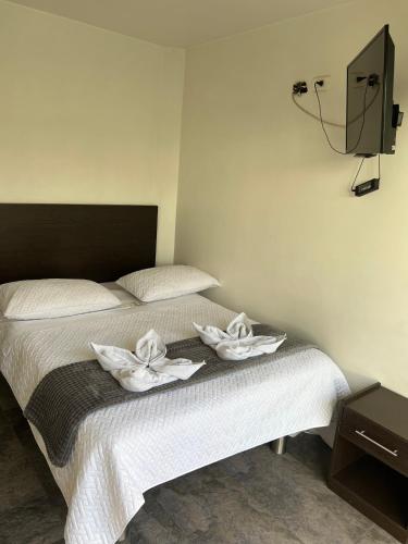a bedroom with a bed with two towels on it at Hotel San Martin Mosquera in Mosquera