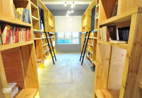 a room filled with wooden shelves with books at Route Five Hostel Dorm Kuala Selangor in Kuala Selangor