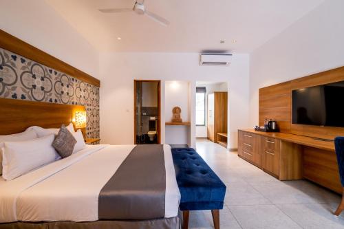 a bedroom with a large bed and a flat screen tv at Chalston Beach Resort in Calangute